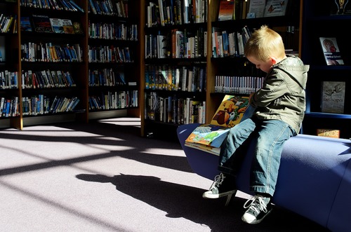Stock Photo Children reading comic books in the library