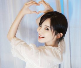 Stock Photo Cute girl heart shaped gesture