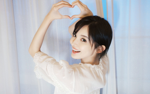 Stock Photo Cute girl heart shaped gesture