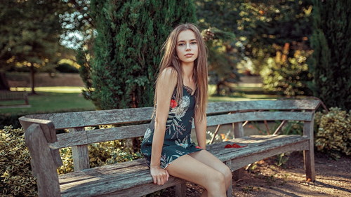 Stock Photo Elegant girl sitting on bench