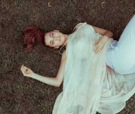 Stock Photo Girl lying on the grass looks at the sky