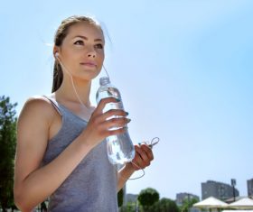 Stock Photo Pretty girl holding bottle of mineral water