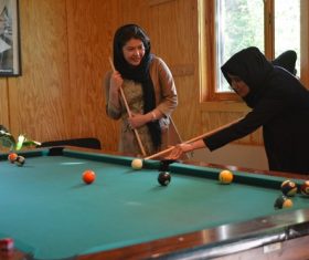Stock Photo Two women playing billiards