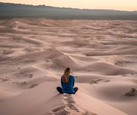 Stock Photo Woman sitting on desert sand dunes