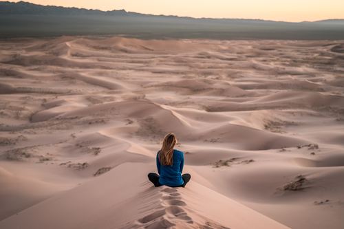 Stock Photo Woman sitting on desert sand dunes