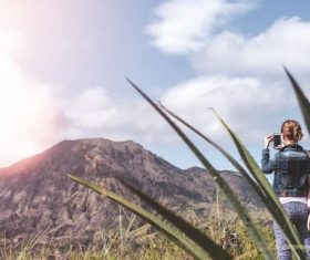 Stock Photo Women use smartphone to shoot volcano