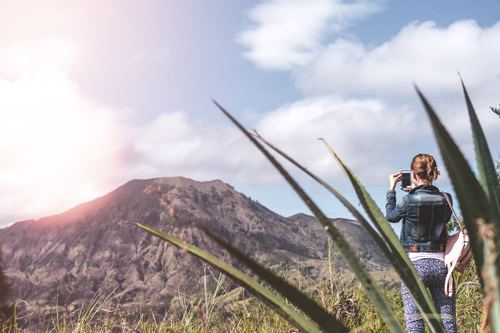 Stock Photo Women use smartphone to shoot volcano