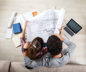 Stock Photo Young Couple Examing Blueprints of they New House 01