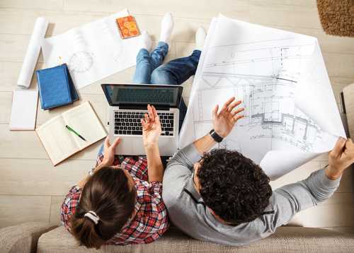 Stock Photo Young Couple Examing Blueprints of they New House 02