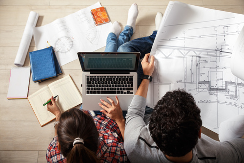 Stock Photo Young Couple Examing Blueprints of they New House 03