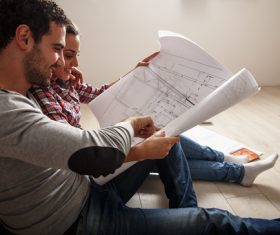 Stock Photo Young Couple Examing Blueprints of they New House 04