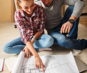 Stock Photo Young Couple Examing Blueprints of they New House 05