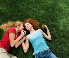 Two girls lying on the grass Stock Photo 01