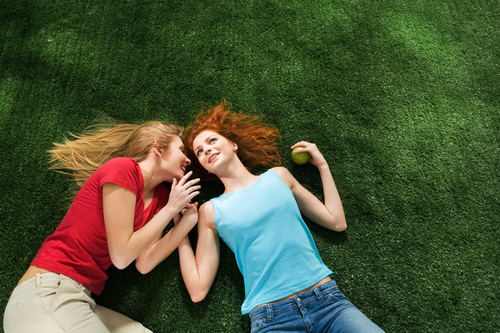 Two girls lying on the grass Stock Photo 01