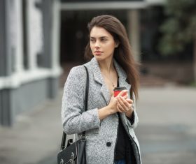 Woman in warm clothes holds coffee Stock Photo
