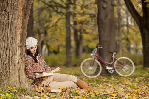 Woman reading a book under the tree in autumn Stock Photo 02