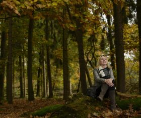 Woman sitting in the woods enjoying nature Stock Photo