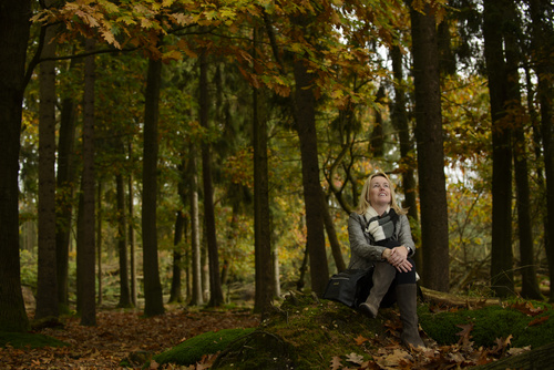 Woman sitting in the woods enjoying nature Stock Photo