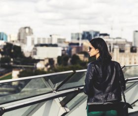 Woman standing on the overpass watching the cityscape Stock Photo