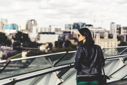 Woman standing on the overpass watching the cityscape Stock Photo