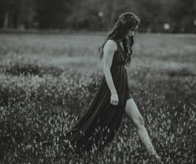 Woman walking in field black and white photo Stock Photo