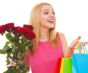 Young beauty holding shopping bags and flowers Stock Photo