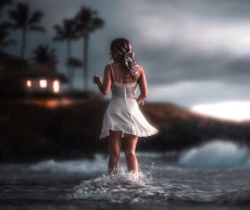 Back shadow of beautiful woman standing in the sea water Stock Photo