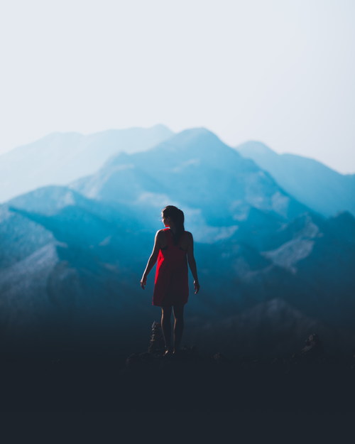 Beautiful girl standing on the top of the mountain back shadow Stock Photo