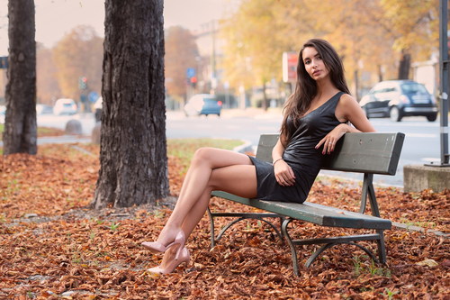 Beautiful woman sitting on a park bench Stock Photo