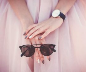 Closeup of woman holding sunglasses in hand Stock Photo