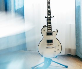 Electric guitar in the corner of the room Stock Photo