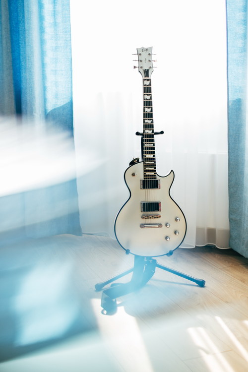 Electric guitar in the corner of the room Stock Photo