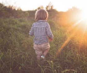 Little child running on the grass Stock Photo