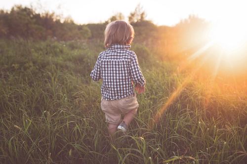 Little child running on the grass Stock Photo
