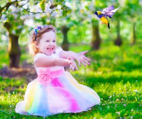 Little girl and bird on the grass Stock Photo