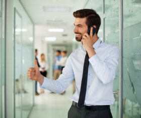 Man standing in the company corridor using phone Stock Photo 02