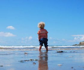 Stock Photo Little boy playing with water at the beach