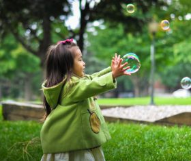 Stock Photo Little girl catching bubbles