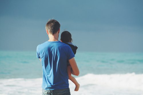 Stock Photo Man holding daughter watching the sea