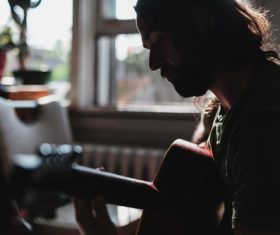 Stock Photo Man playing guitar at home