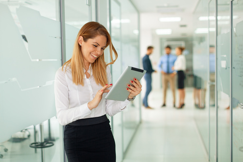 Stock Photo Woman standing in the hallway using tablet