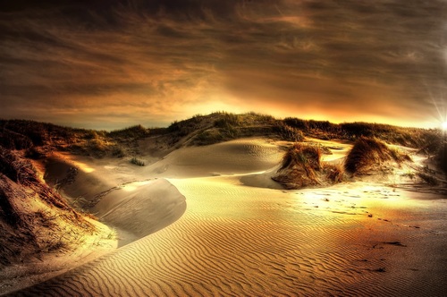 The afterglow of the sunset shines on the sand dunes Stock Photo