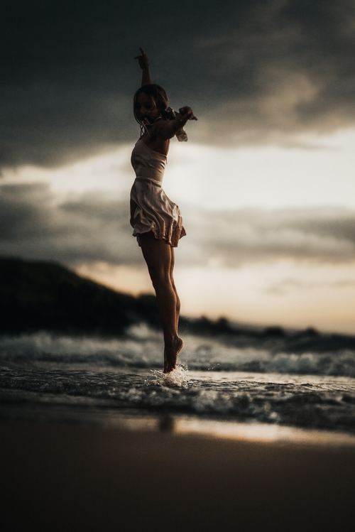Woman jumping on the beach Stock Photo