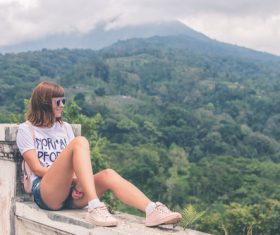 Woman sitting on the bridge looking at the scenery Stock Photo
