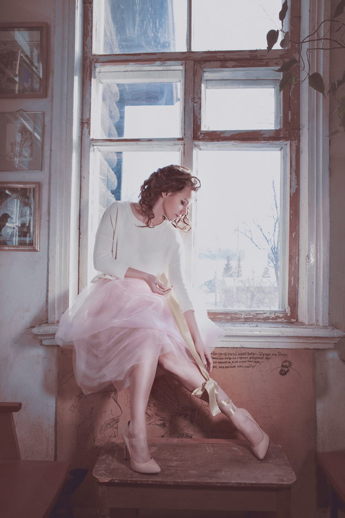 Woman sitting on the window sill with bow Stock Photo
