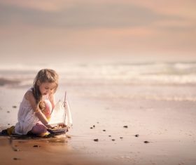 Cute little girl playing with boat model Stock Photo