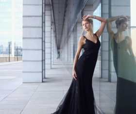 Female model wearing black long skirt taking pictures outdoors Stock Photo