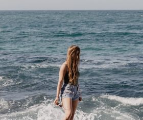 Girl standing on the reef looking at the sea Stock Photo