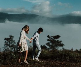 Lovers walking hand in hand on the mountain Stock Photo