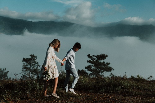 Lovers walking hand in hand on the mountain Stock Photo